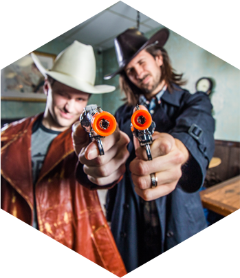 Cowboys holding guns in The Saloon Escape Room